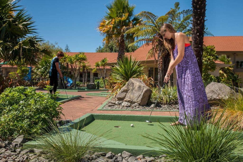 Regal Palms Resort Rotorua Bagian luar foto A woman playing mini golf